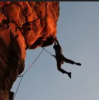 Grimpeur devant un lever de soleil